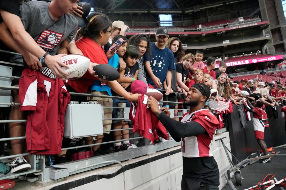 Arizona Cardinals free safety Budda Baker (3) signs autographs for fans during training camp at State Farm Stadium in Glendale on Aug. 8, 2022.