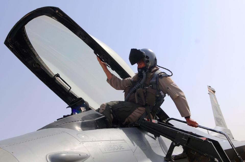 A pilot climbs into an F-16 Fighting Falcon before flying a combat mission over Iraq in 2008.
