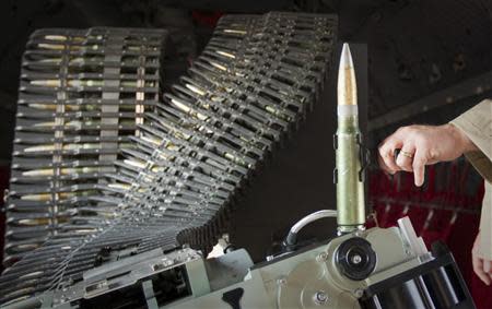 An exhibitor shows the bullets used by a portable automated long range gun system which can be used in cargo aircraft during the Dubai Airshow November 18, 2013. REUTERS/Caren Firouz