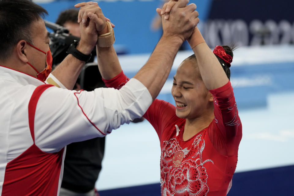 Tang Xijing, of China, celebrates with her coach after performing on the balance beam during the artistic gymnastics women's apparatus final at the 2020 Summer Olympics, Tuesday, Aug. 3, 2021, in Tokyo, Japan. (AP Photo/Ashley Landis)