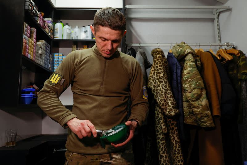 Hairdresser and Ukrainian Territorial Defence unit volunteer works at a beauty salon, in Kyiv