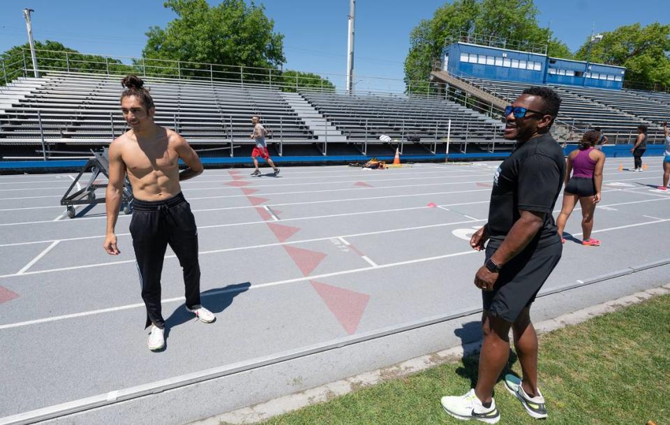 Coach Demitrius Snaer, right, talks with his team members including relay sprinter Kainoa Ontai, left, during practice at Modesto Junior College in Modesto, Calif., Tuesday, May 14, 2024.