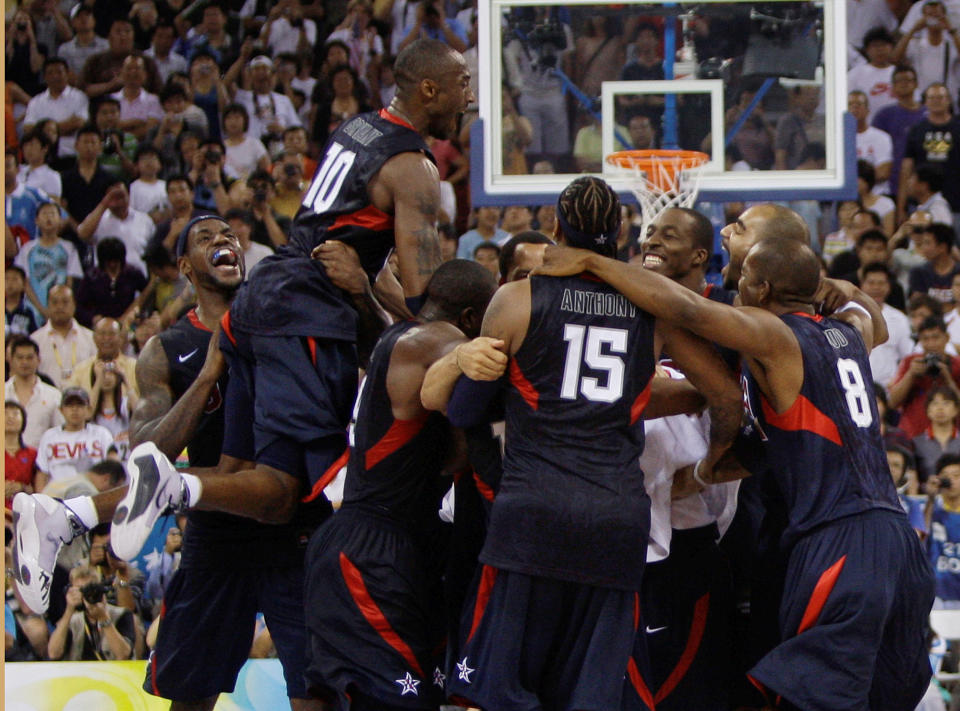 FILE - USA's Kobe Bryant (10) leaps on top of teammates as they celebrate after beating Spain 118-107 in the men's gold medal basketball game at the Beijing 2008 Olympics in Beijing on Aug. 24, 2008. A documentary on the 2008 U.S. men’s basketball team known as the “Redeem Team,” with executive producers including Lebron James and Dwayne Wade, will premiere on Netflix in October. (AP Photo/Dusan Vranic, File)