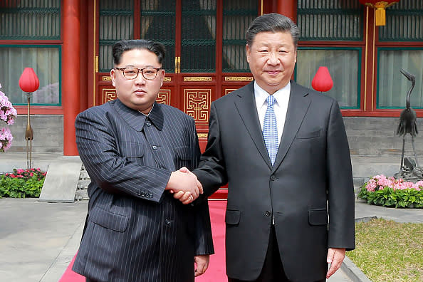 China’s President Xi Jinping (R) shaking hands with North Korean leader Kim Jong Un in Beijing. Kim was treated to a lavish welcome by the Chinese president during a secretive trip to Beijing as both sides seek to repair frayed ties ahead of landmark summits with Seoul and Washington. (Photo credit: AFP/Getty Images)