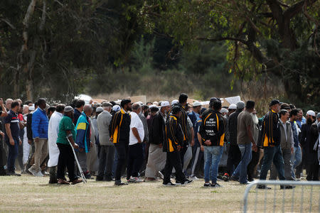 Bodies of victims of the mosque attacks are carried during the burial ceremony at the Memorial Park Cemetery in Christchurch, New Zealand March 20, 2019. REUTERS/Jorge Silva