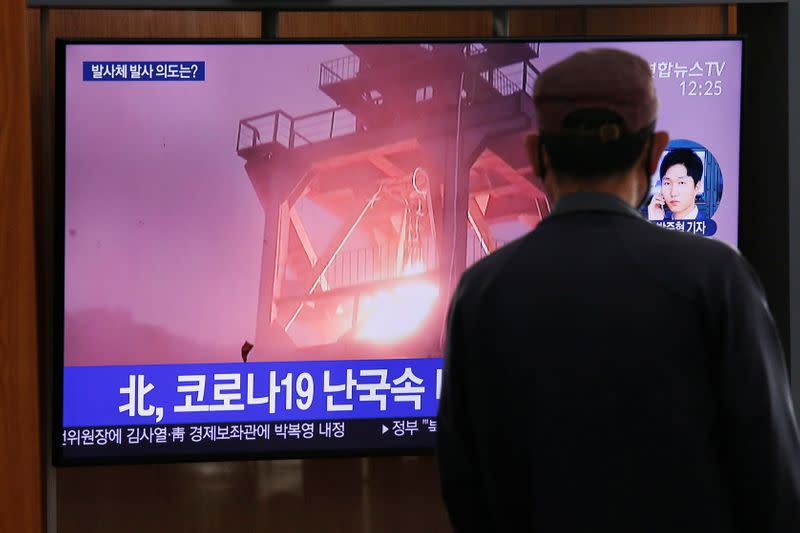 A man watches a TV broadcasting file footage for a news report on North Korea firing an unidentified projectile, in Seoul