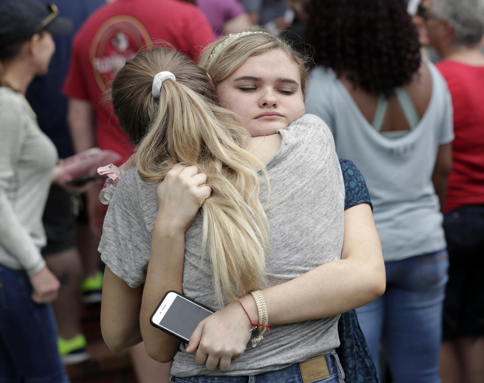 <p>Students hug outside a staging area at the First Baptist Church of Ocala as parents arrive to pick them up after a shooting incident at nearby Forest High School, Friday, April 20, 2018, in Ocala, Fla. (Photo: John Raoux/AP) </p>