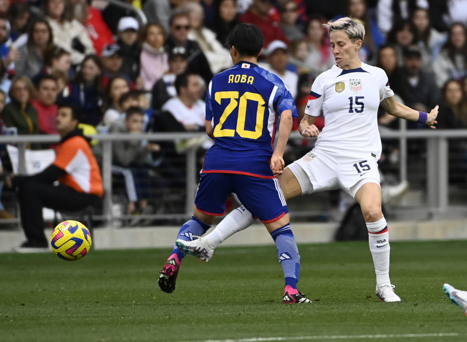 U.S. forward Megan Rapinoe (15) kicks the ball away from Japan midfielder Aoba Fujino (20) during the second half of a SheBelieves Cup soccer match Sunday, Feb. 19, 2023, in Nashville, Tenn. The United States won 1-0. (AP Photo/Mark Zaleski)