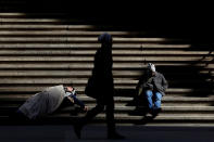 <p>A homeless person (left) sleeps on the steps of Federal Hall on Wall St. in New York City, Feb. 28, 2017. (Brendan McDermid/Reuters) </p>