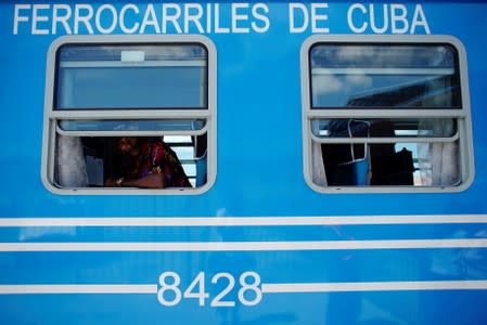 Juan Bitancourt peers from a window inside a Cuba's Chinese-made passenger train car before departing from La Coubre train station in Havana