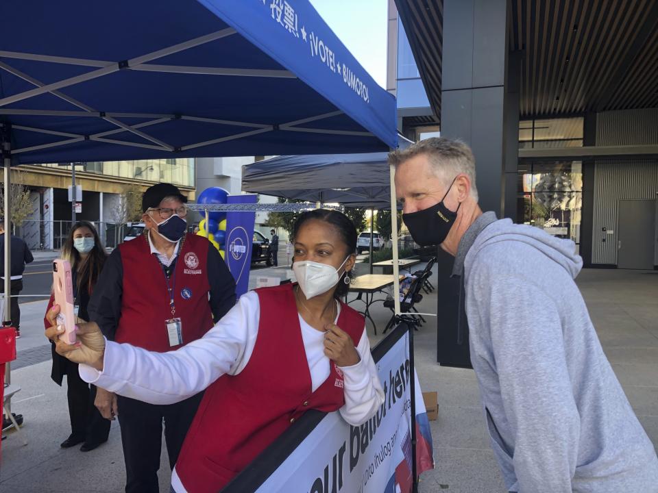 Golden State Warriors coach Steve Kerr poses for a selfie with voting worker Jujuana Williams of Oakland on Saturday, Oct. 31, in San Francisco. (AP Photo/Janie McCauley)