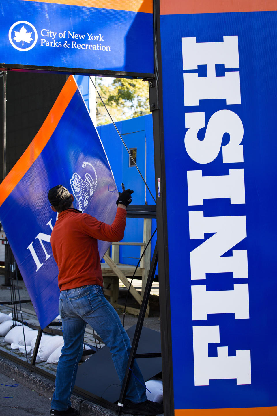 FILE - In this Nov. 3, 2012 file photo, a worker dismantles sponsorship signs at the Central Park finish line for the canceled New York Marathon in New York. The increased security will be unmistakable for the Nov. 3, 2013, marathon, from barriers around Central Park to added checkpoints. (AP Photo/ John Minchillo, File)