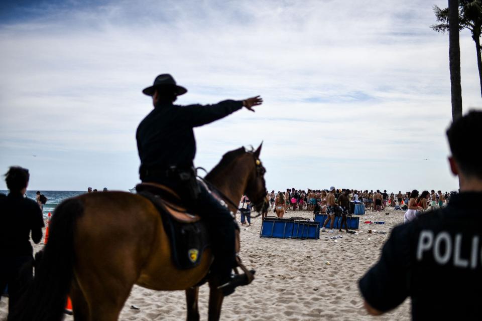 Fort Lauderdale Mounted Police officers escort revelers off the beach on Las Olas Boulevard in Fort Lauderdale, Florida, March 16, 2022. Music, dancing, alcohol and tiny swimsuits -- spring vacation in the United States, popularly known as "spring break," brings thousands of young people to south Florida every year for a few days of uncontrolled fun, much to the chagrin of residents in cities like Miami Beach.