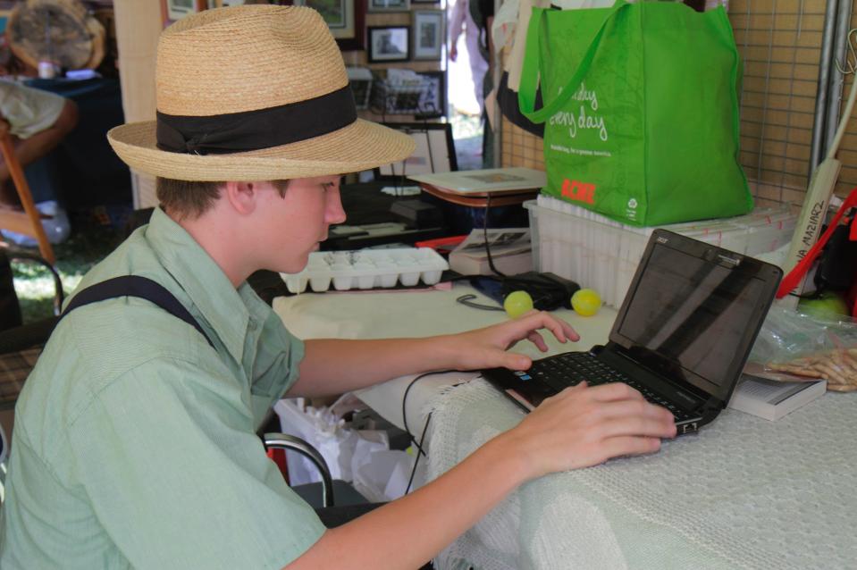 A boy using a laptop at the Kutztown Folk Festival.