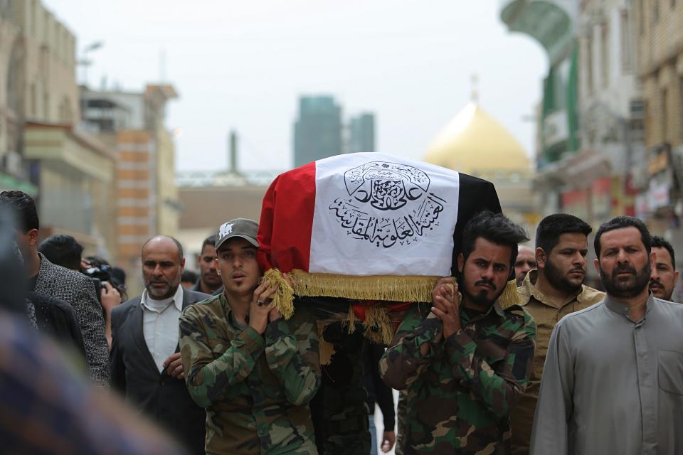 Mourners and militia fighters carry the flag-draped coffins of two fighters of the Popular Mobilization Forces who were killed during the US attack on against militants in Iraq, during their funeral procession at the Imam Ali shrine in Najaf, Iraq, Saturday, March 14, 2020. The U.S. launched airstrikes on Thursday in Iraq, targeting the Iranian-backed Shiite militia members believed responsible for a rocket attack that killed and wounded American and British troops at a base north of Baghdad. (AP Photo/Anmar Khalil)