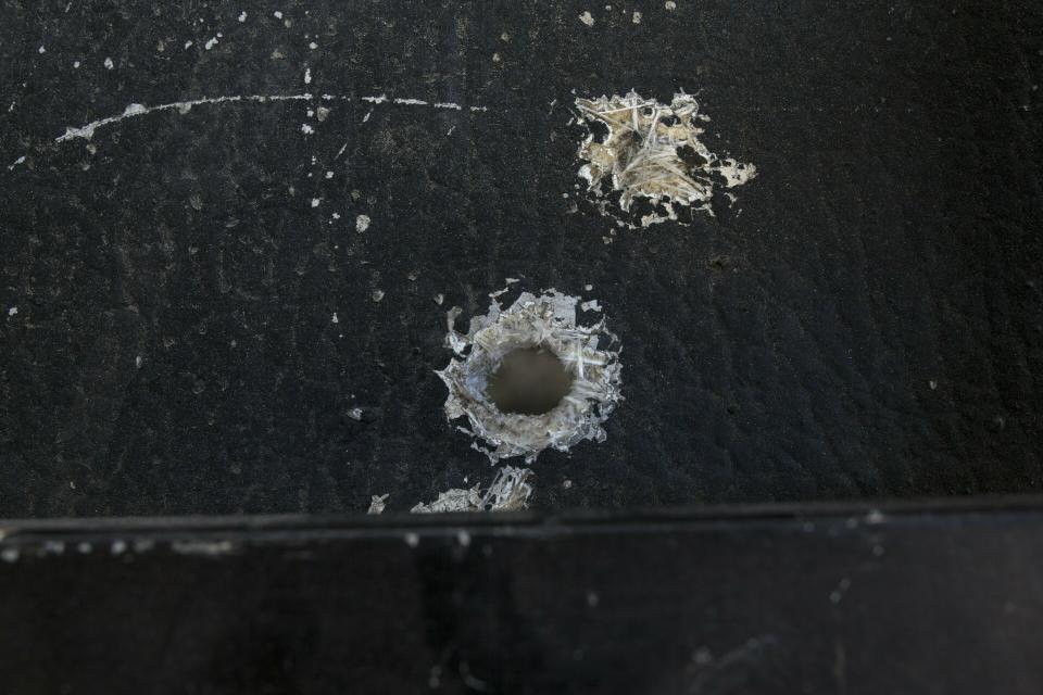 Bullet holes penetrate the roof of a pick-up truck that was used as a shield by anti-government protesters who were allegedly under fire by National Guards, at the site where 19-year-old Nick Samuel Oropeza was killed the previous week in Caracas, Venezuela, Wednesday, Jan. 30, 2019. Socialist party chief Diosdado Cabello and Defense Minister Gen. Vladimir Padrino Lopez have insisted the military follows the constitution and respects human rights. (AP Photo/Rodrigo Abd)