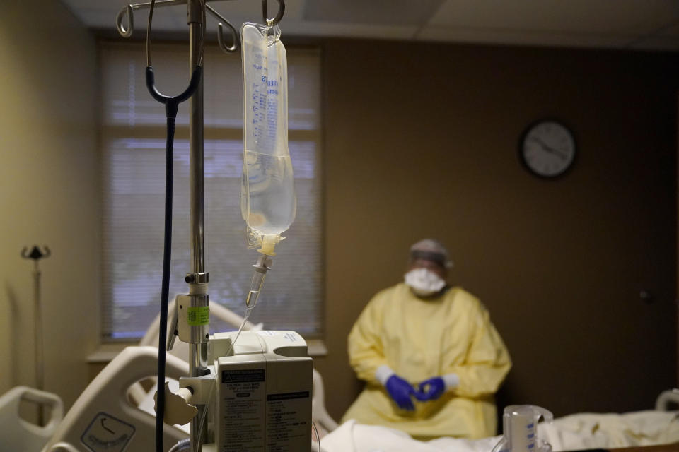 FILE - In this Nov. 24, 2020, file photo, Dr. Shane Wilson talks with a patient while performing rounds in a portion of Scotland County Hospital set up to isolate and treat COVID-19 patients in Memphis, Mo. The U.S. has seen a dramatic turnaround since December and January, when hospitals were teeming with patients after holiday gatherings and pandemic fatigue caused a surge in cases and deaths. (AP Photo/Jeff Roberson, File)