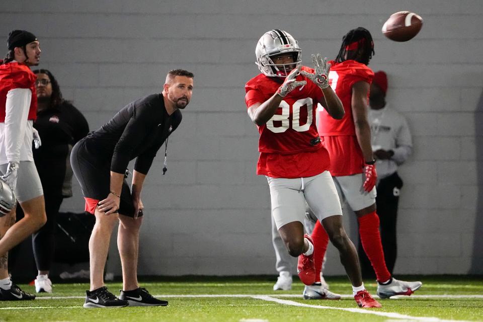 Mar 9, 2023; Columbus, Ohio, USA;  Ohio State Buckeyes offensive coordinator Brian Hartline watches as wide receiver Noah Rodgers (80) catches a pass during spring football practice at the Woody Hayes Athletic Center. Mandatory Credit: Adam Cairns-The Columbus Dispatch