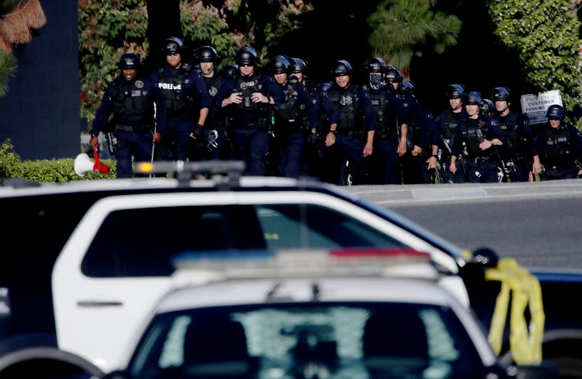 LOS ANGELES, CALIF. - JULY 24, 2022. LAPD officers and Sheriff's deputies stage at the entrance to Peck Park in San Pedro, where seven people were injured in a shooting on Sunday afternoon, July 24, 2022. (Luis Sinco / Los Angeles Times)