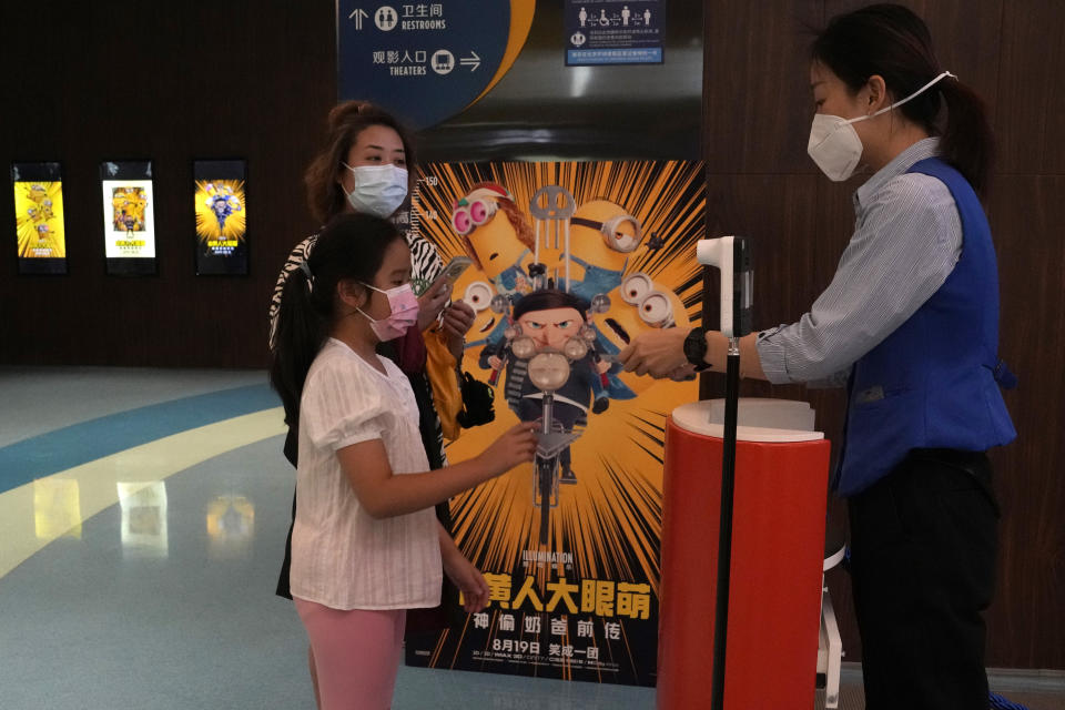 Visitors to a cinema showing the latest "Minions: The Rise of Gru" movie get their tickets checked in Beijing Wednesday, Aug. 24, 2022. The latest “Minions” movie reinforces a message for Chinese audiences that viewers in other countries won’t see: Crime doesn’t pay.(AP Photo/Ng Han Guan)