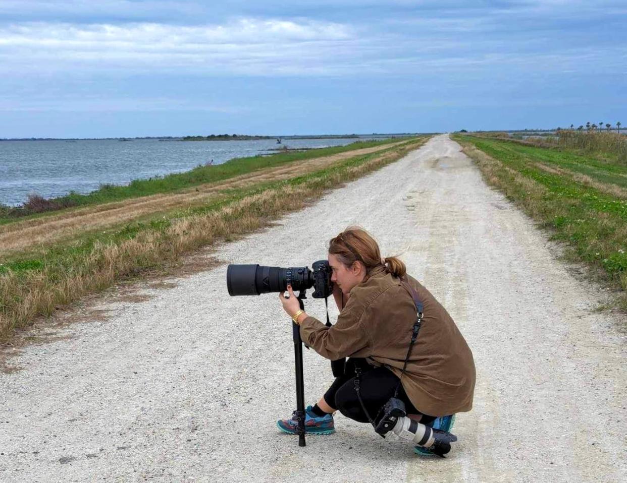Visuals journalist Kaila Jones taking photos of waterfowl hunters as they search the Fellsmere Grade Recreation Area, also known as Farm 13 or the Stick Marsh, on Sunday, Jan. 14, 2024, in Fellsmere.