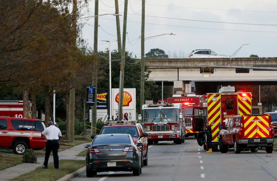 In this Sunday, Dec. 15, 2019 photo, officials respond to the scene of a mercury spill on the intersection of Westview Drive and West Sam Houston Parkway North in Houston. A person has been taken into custody for questioning after dozens of people were decontaminated as a precaution due to trace amounts of mercury spilled at three locations in Houston, the FBI said Monday. (Godofredo A. Vásquez/Houston Chronicle via AP)