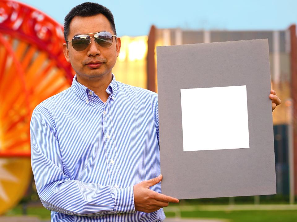 Developer Xiulin Ruan holds up a sample of the ‘whitest paint’  (Purdue University/Jared Pike)