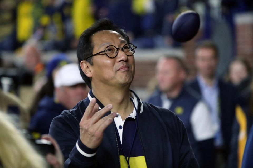 Michigan president Santa Ono throws footballs to fans during during the second half of Michigan's 41-13 win on Saturday, Nov 4, 2023, in Ann Arbor.