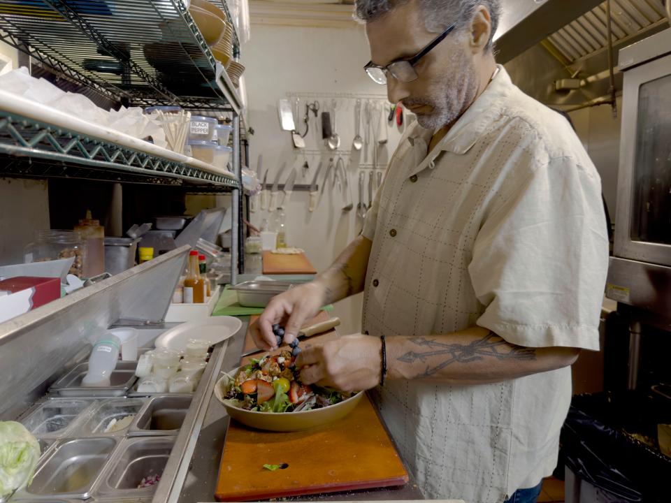 Chef David Raigoza puts a colorful salad together at Chef David's Kitchen & Catering in Santa Paula. Raigoza is fighting stage 4 cancer.