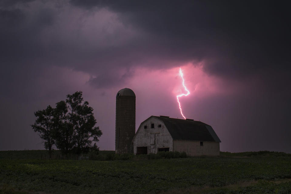 Lighting strikes over a barn surrounded by a soybean crop in Donnellson, Iowa, July 13, 2012. U.S. ranchers are rushing to sell off some of their cattle as the worst drought in nearly 25 years dries up pastures, thins hay supplies and sends feed costs sky-rocketing. The drought in the Midwest follows another one last year in the southern Plains. REUTERS/Adrees Latif