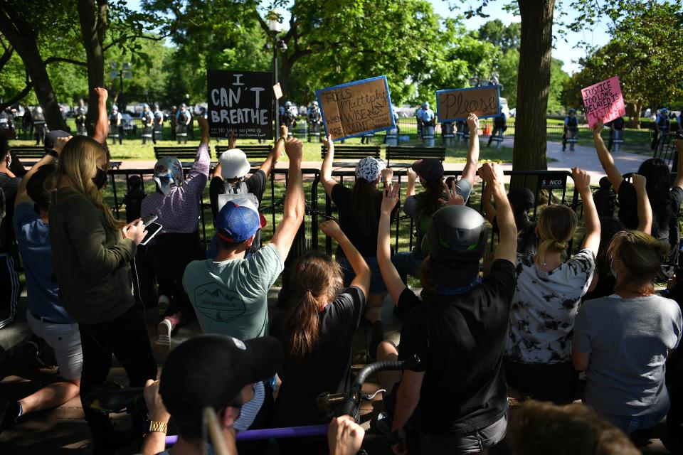 Protesters take a knee and raise their fists in Lafayette Square near the White House on June 1, 2020. 