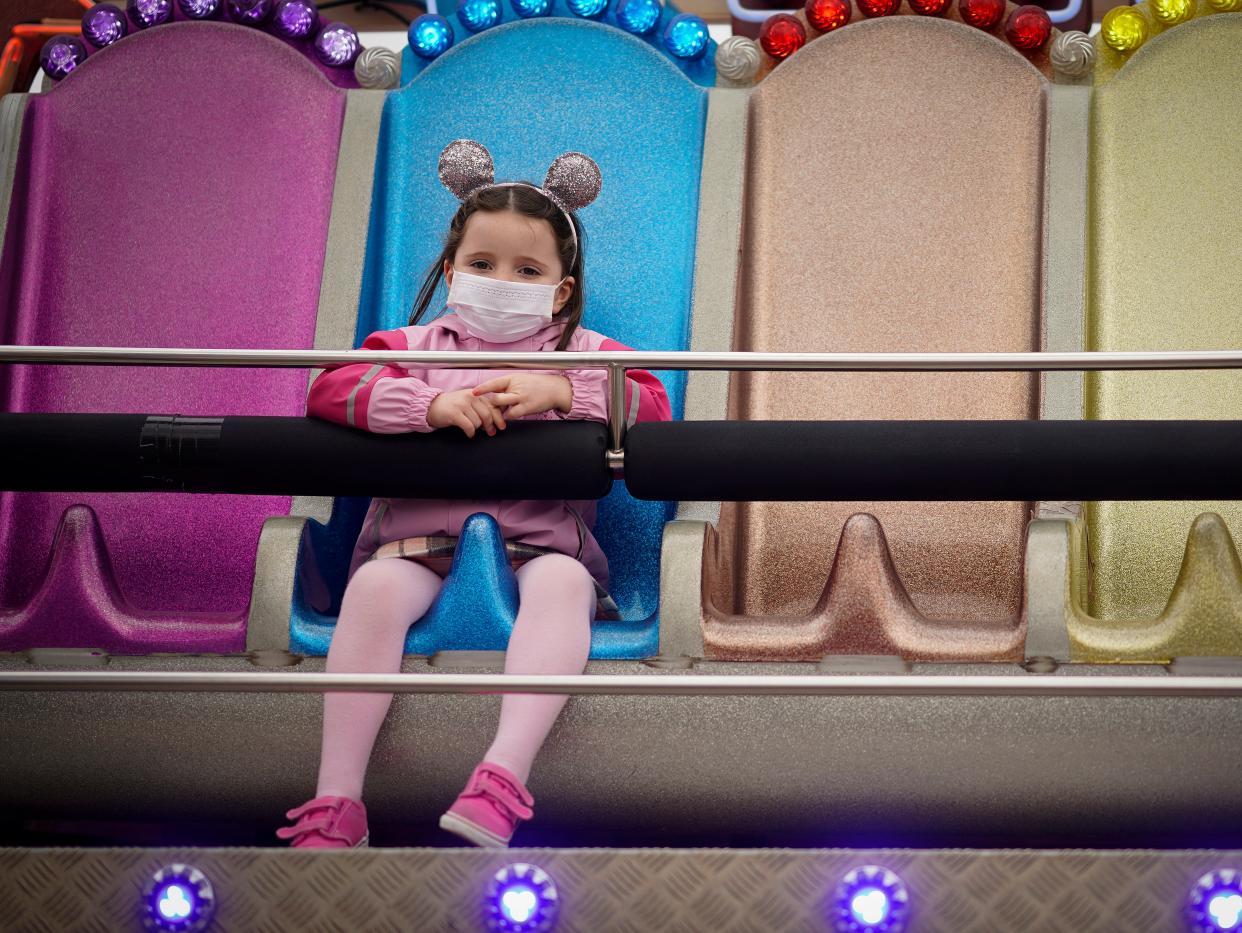 <p>A young girl wearing a mask at a Blackpool fairground</p> (Getty)