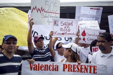 Protesters hold placards during a gathering in demand for medicines in Caracas, Venezuela August 27, 2015. REUTERS/Marco Bello