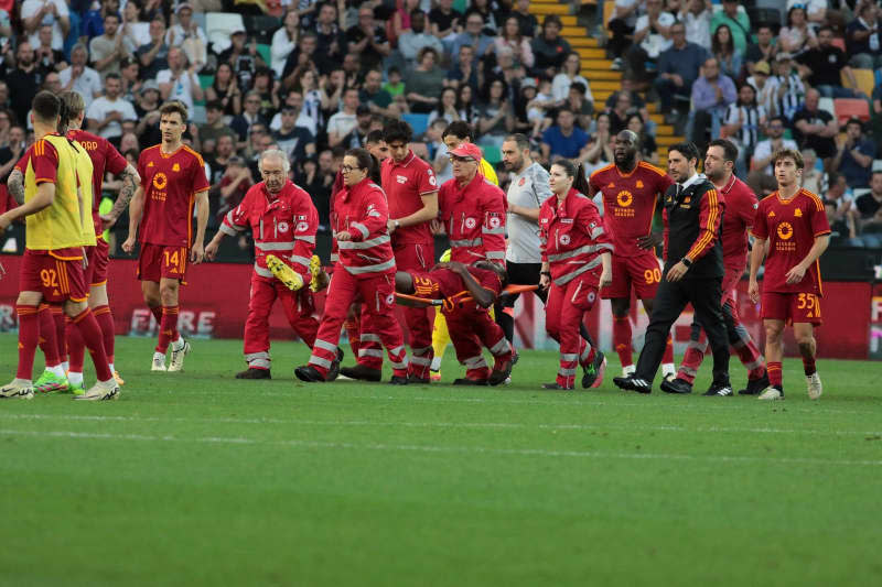 Rome's Evan Ndicka (C) is carried off the pitch by paramedics after a medical emergency during the Italian serie A soccer match between Udinese Calcio and AS Rom at Bluenergy Stadium. Andrea Bressanutti/LaPresse via ZUMA Press/dpa