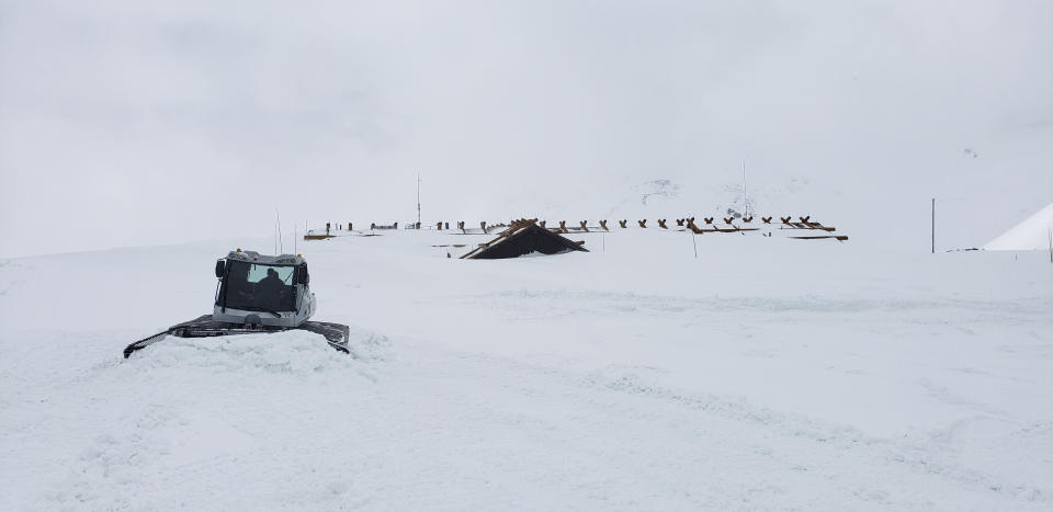 This May 29, 2019, photo provided by the National Park Service shows a plow clearing roof-high snow from the parking lot at the Alpine Visitor Center in Rocky Mountain National Park, Colo. The building is 11,796 feet (3,595 meters) above sea level. Heavy winter snow and a cold, wet May in the Rocky Mountains are sending a welcome surge of spring runoff into the rivers of the Southwestern U.S., fending off a water shortage but threatening to push some streams over their banks. (National Park Service via AP)