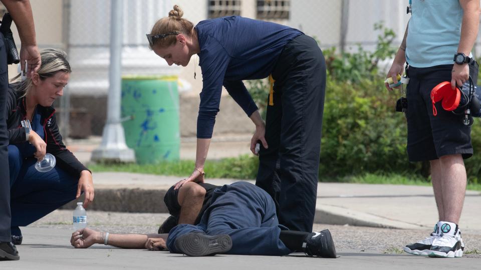 Healthcare workers participating in a Camden County outreach program rush to render aid to a man who collapsed in the middle of a nearby busy Camden intersection on July 20, 2023.