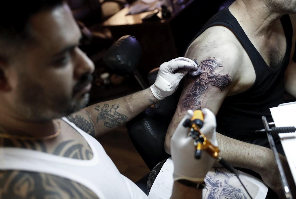 Christian Palestinian tattoo artist Walid Ayash draws a tattoo on the arm of a Coptic Egyptian pilgrim on April 28, 2016, at his studio in Bethlehem. <a href="https://www.gettyimages.com/detail/news-photo/christian-palestinian-tattoo-artist-walid-ayash-draws-a-news-photo/525904928?adppopup=true" rel="nofollow noopener" target="_blank" data-ylk="slk:Thomas Coex /AFP via Getty Images;elm:context_link;itc:0;sec:content-canvas" class="link ">Thomas Coex /AFP via Getty Images</a>