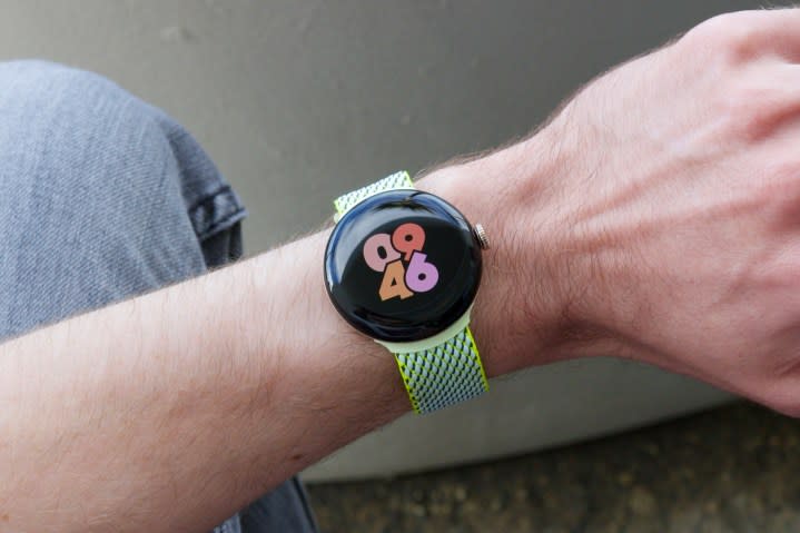 A person sitting down and wearing the Google Pixel Watch 2.