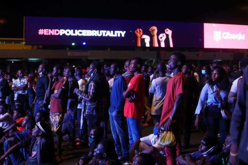 Demonstrators gather beside an electronic billboard displaying the slogan "End police brutality", during a protest in Lagos