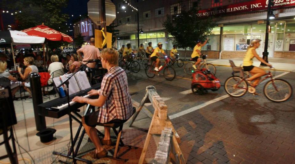 A singer for the Tavern on Main crowd also entertains bicyclists on East Main Street.