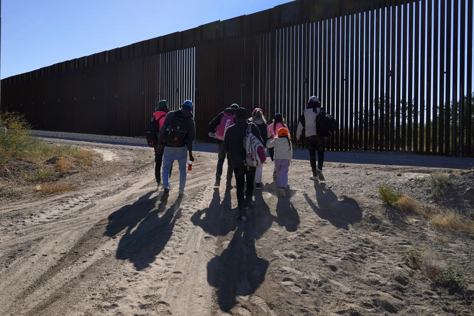 A group of migrants walk along the border in a remote part of the Arizona desert as they join hundreds of migrants gathering along the border Tuesday, Dec. 5, 2023, in Lukeville, Ariz. (AP Photo/Ross D. Franklin)