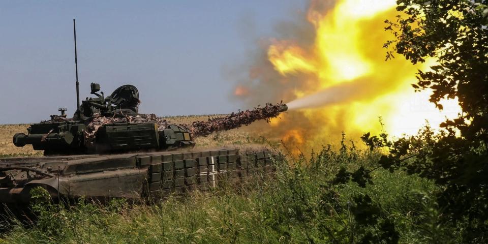 Ukrainian servicemen fire with a tank towards Russian troops