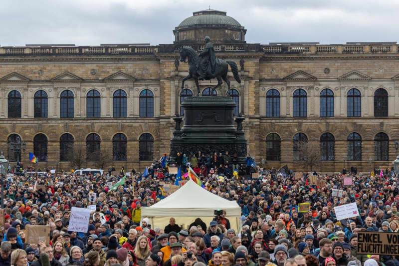 People take part in a large demonstration of the Dresden action alliance "Wir sind die Brandmauer Dresden" against right-wing extremism at the Theater square in Dresden. Daniel Schäfer/dpa