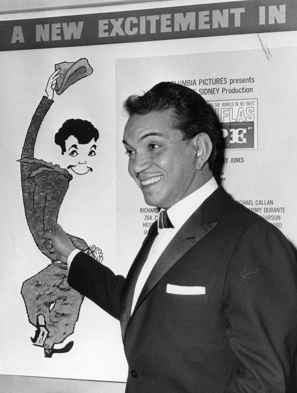 Cantinflas points proudly to a poster of himself at the Columbia film theatre on Shaftestbury Avenue, London, W1.  (Photo by Sydney O'Meara/Hulton Archive/Getty Images)