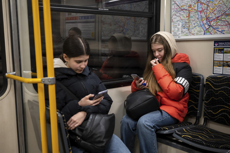 Ukrainian refugee circus student twins Anna and Mariia Lysytska travel together on a subway to their training facility in Budapest, Hungary, Monday, Feb. 13, 2023. More than 100 Ukrainian refugee circus students, between the ages of 5 and 20, found a home with the Capital Circus of Budapest after escaping the embattled cities of Kharkiv and Kyiv amid Russian bombings. (AP Photo/Denes Erdos)