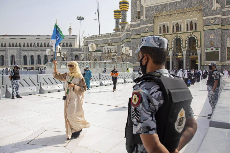 In this photo released by the Saudi Media Ministry, security personnel standby as a limited numbers of pilgrims arrive keeping social distancing to limit exposure and the potential transmission of the coronavirus, at the Grand Mosque in the Muslim holy city of Mecca, Saudi Arabia, Wednesday, July 29, 2020. The hajj, which started on Wednesday, is intended to bring about greater humility and unity among Muslims. (Saudi Media Ministry via AP)