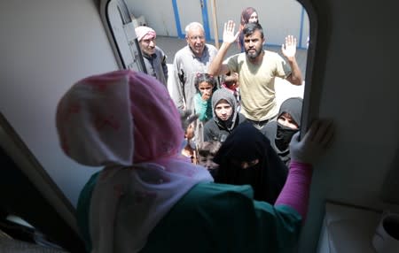 Displaced Syrian refugees wait for their turn to get treatment at a mobile dental clinic near Azaz