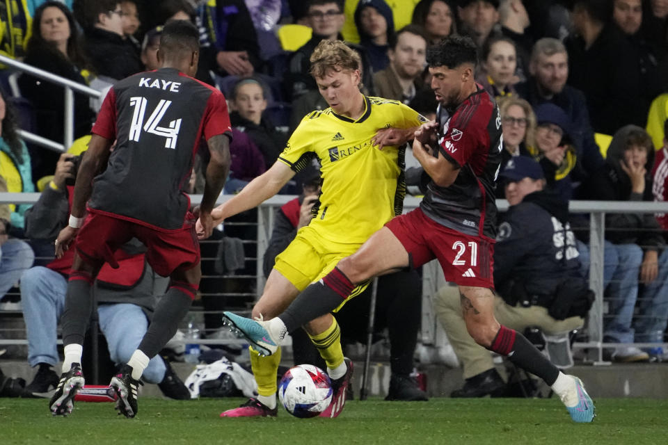 Nashville SC forward Jacob Shaffelburg, center, is defended by Toronto FC's Mark-Anthony Kaye (14) and Jonathan Osorio (21) during the second half of an MLS soccer match Saturday, April 8, 2023, in Nashville, Tenn. (AP Photo/Mark Humphrey)