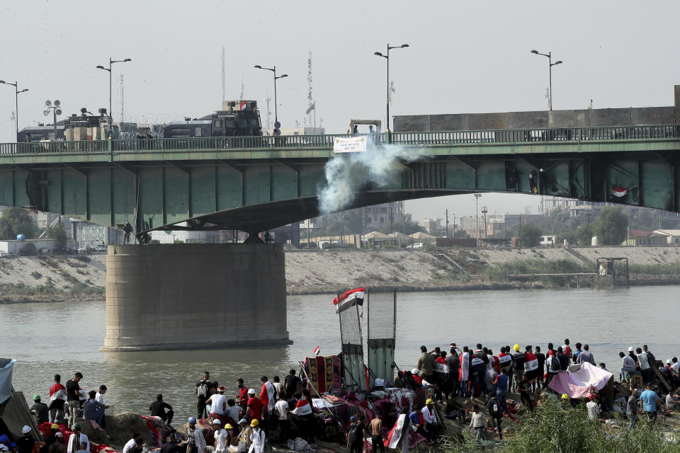 Iraqi security forces use tear gas to disperse anti-government protesters during ongoing protests in Baghdad, Iraq, Sunday, Nov. 3, 2019. (AP Photo/Hadi Mizban)