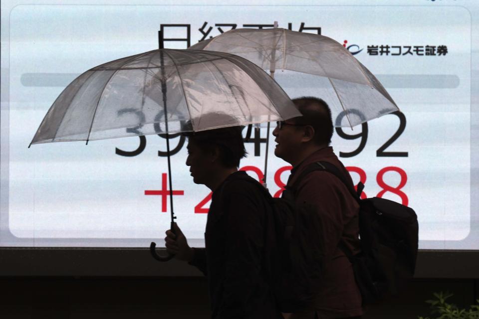 People walk in front of an electronic stock board showing Japan's Nikkei index at a securities firm, Wednesday, Oct. 9, 2024, in Tokyo. (AP Photo/Eugene Hoshiko)